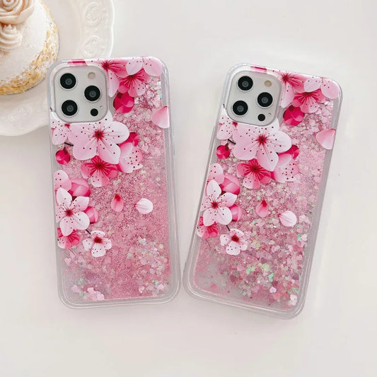 Two iphone cases with pink cherry blossom design on a white background