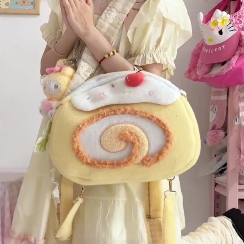 Person holding a plush pastry bag with a cherry on top, surrounded by other plush toys.
