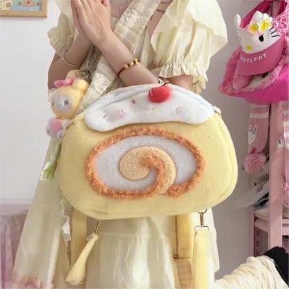 Person holding a plush pastry bag with a cherry on top, surrounded by other plush toys.