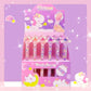 Unicorn-themed stationery set with pens and markers in a display box on a pink background.