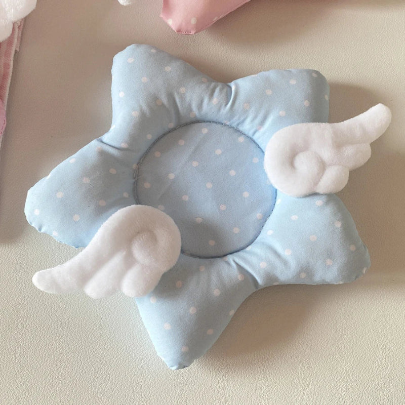 Blue star-shaped coaster with white polka dots and angel wings on a beige background