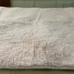 Fluffy white blanket on a bed with a visible texture