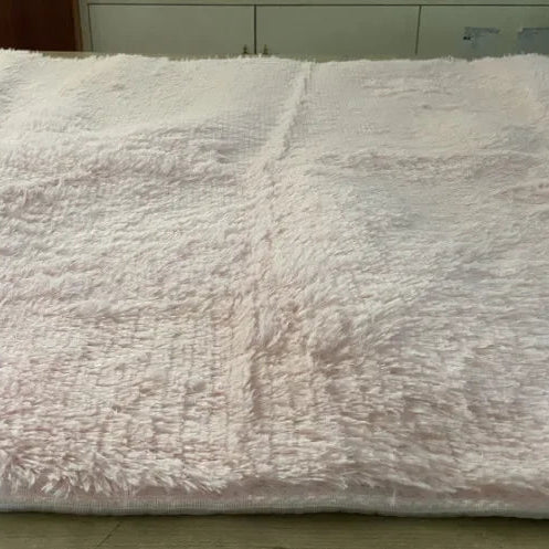 Fluffy white blanket on a bed with a visible texture
