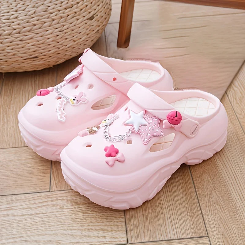Pink sandals with decorative star and bow elements on a wooden floor