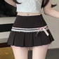 Black pinstripe skirt with a pink ribbon worn by a person indoors.