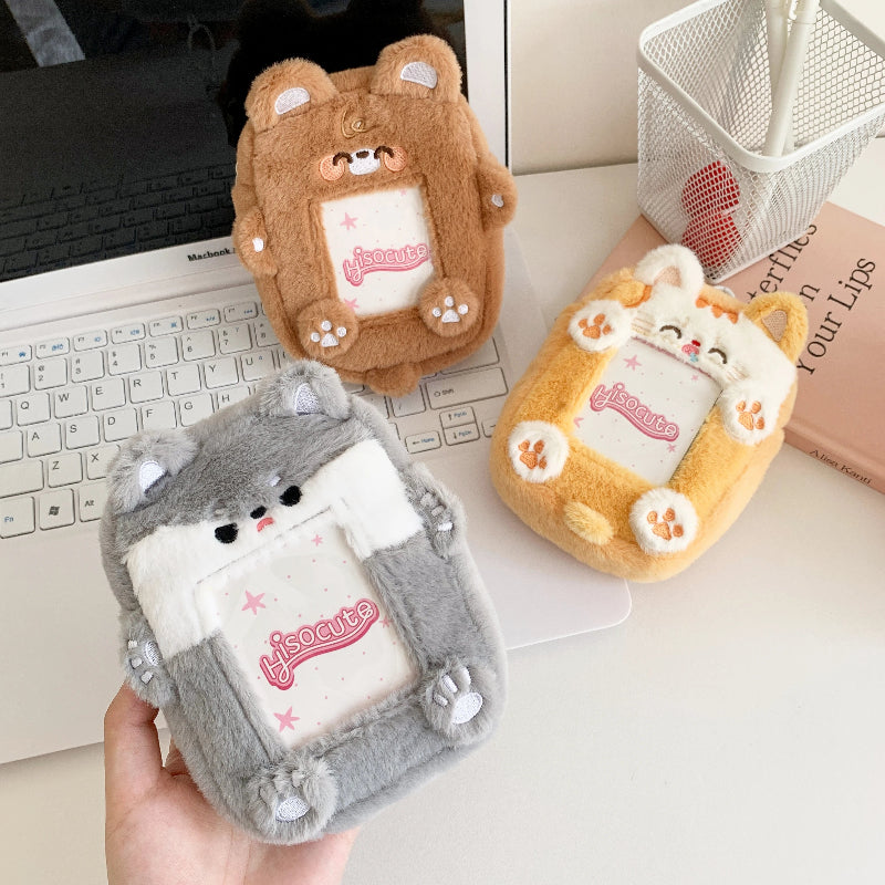 Three cute animal-shaped photocard pouches on a desk with a laptop.