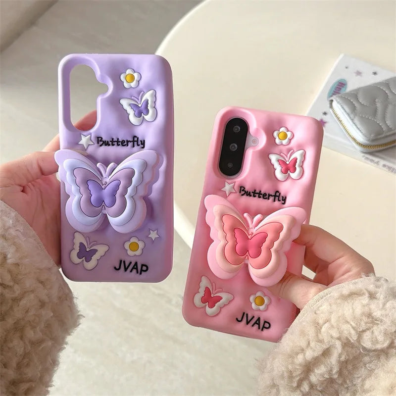 This image is showing two designs that are available for the Kawaii Butterfly Samsung Phone Case, one option is the pink design with a large 3D butterfly in the middle with smaller butterflies around it and some white flowers, the other option is of this the same design but in purple.