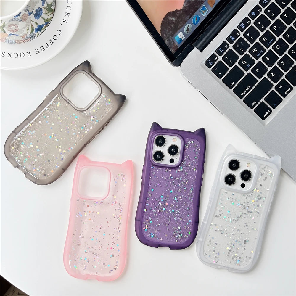 Four glittery phone cases in different colors on a desk with a laptop.