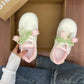 White sneakers with floral decorations inside a cardboard box.