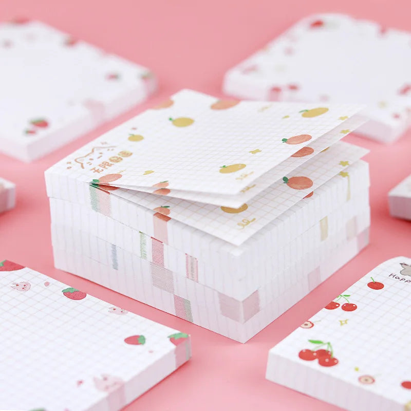 Stack of kawaii sticky notes with fruit patterns on a pink background