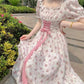 Woman wearing a floral dress with a pink ribbon in an outdoor setting