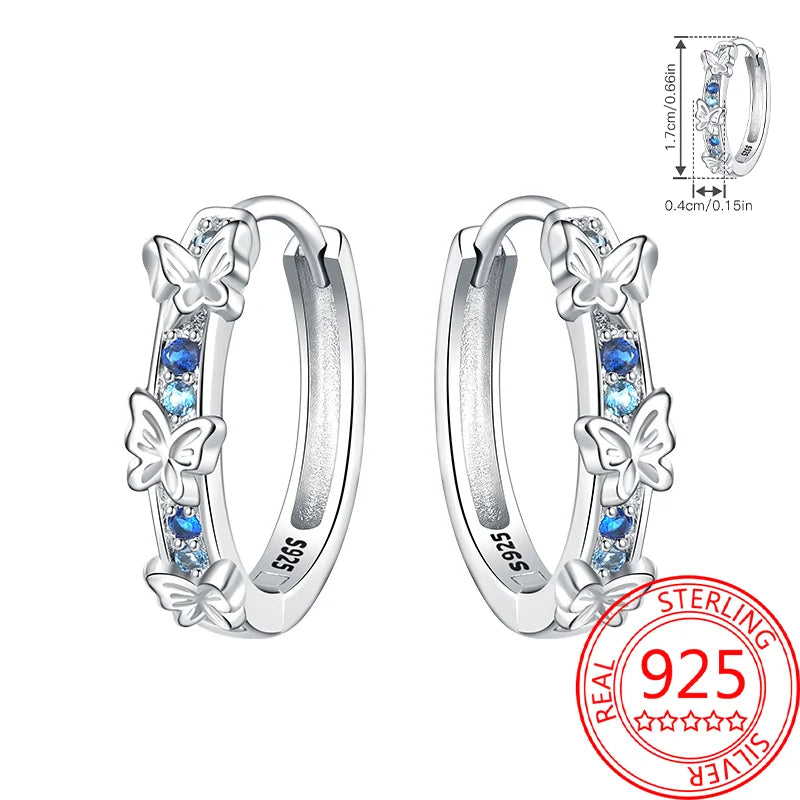 Silver hoop earrings with butterfly designs and blue stones on a white background, featuring a 'Real Sterling 925' stamp.