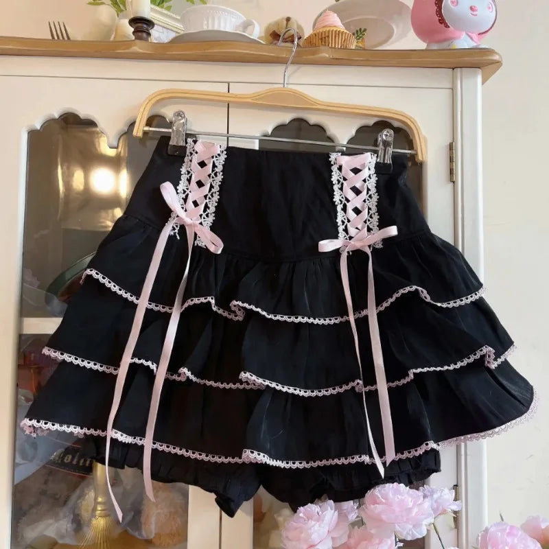 Black lace skirt with pink ribbons on a hanger against a neutral background