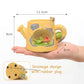 Yellow ceramic teapot with frog design held in a hand, showing measurements and drainage design details.