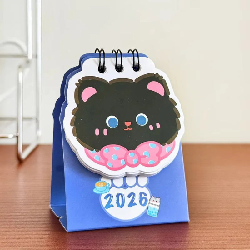 Small desk calendar with a cute black cat design on a blue background, featuring the year 2026.