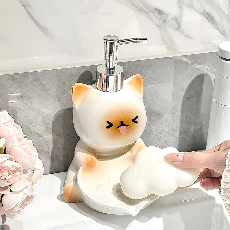 Cat-shaped soap dispenser with a hand pressing a bar of soap out, set against a marble bathroom background.
