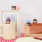 Desk setup with a mug and decorative items on a checkered tablecloth.