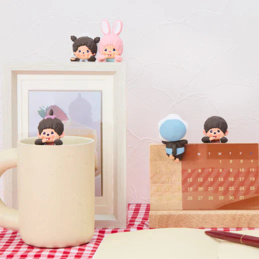 Desk setup with a mug and decorative items on a checkered tablecloth.