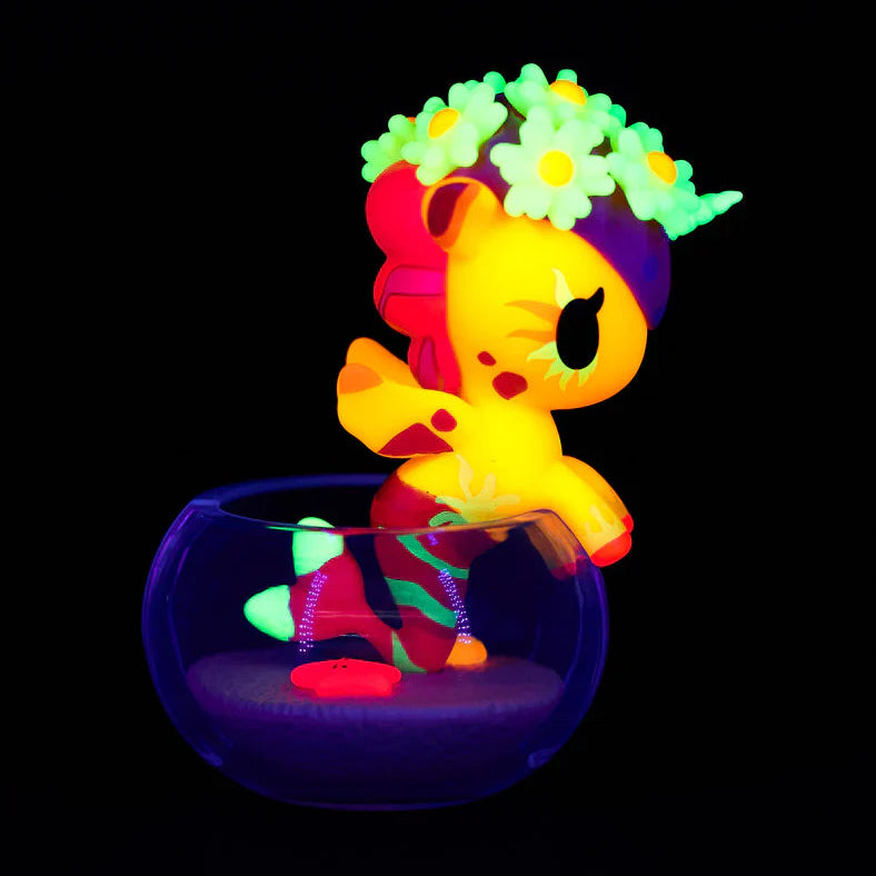 Colorful unicorn figurine with a flower crown in a dark setting