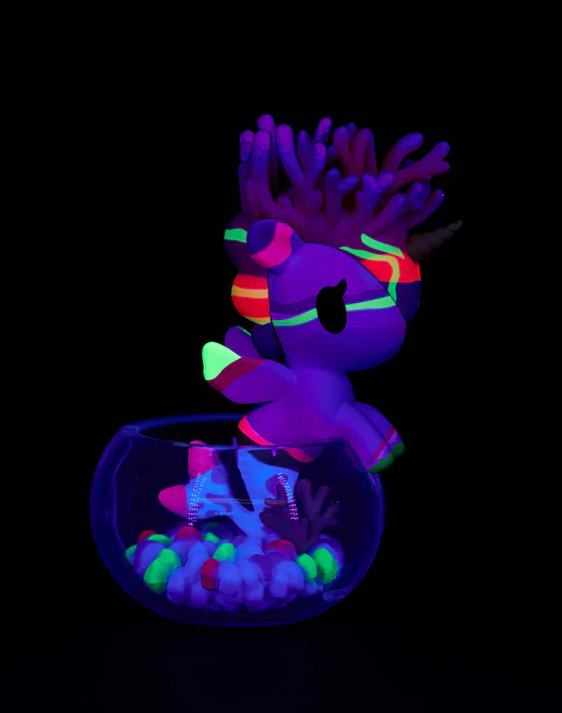 Glowing kawaii unicorn figuring with a fish tank, coral, and fish on a black background
