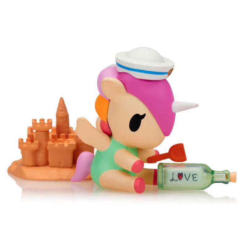 Kawaii blind box toy figure of a unicorn with a sandcastle and bottle on a white background