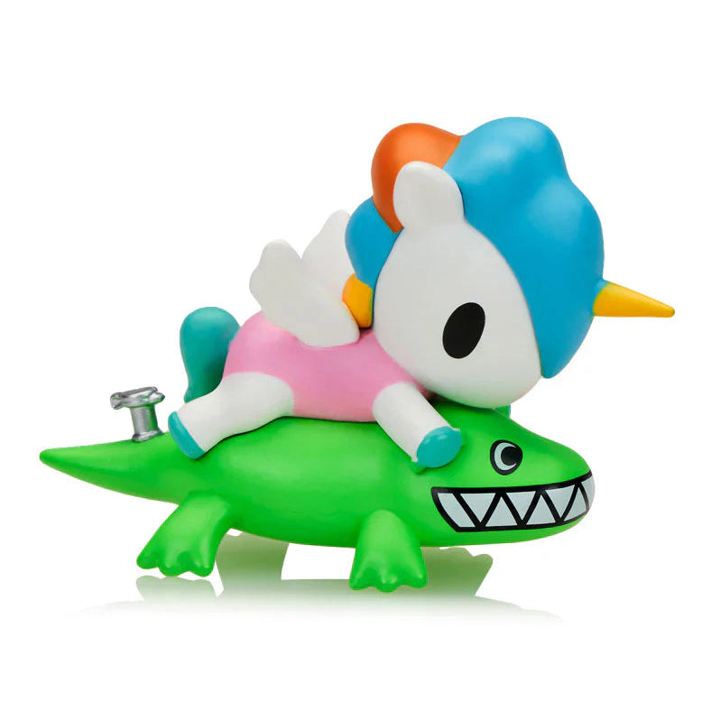 Colorful toy figure of a character with blue hair riding a green creature on a white background