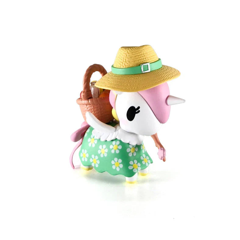 Kawaii Unicorn blind box figurine wearing a yellow hat and green dress with flowers on a white background