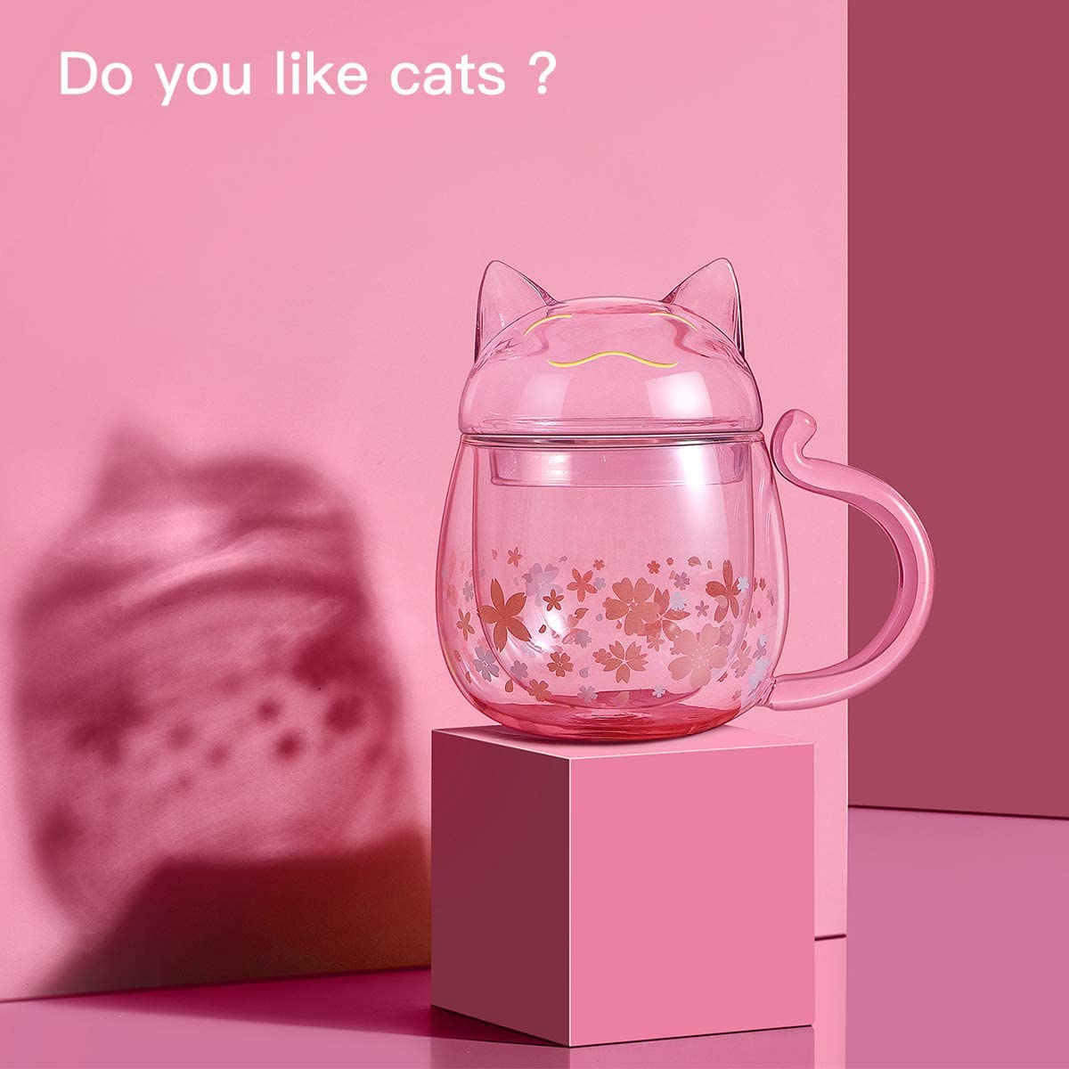 Kawaii Sakura Cat Glass Cup Against a Pink Background