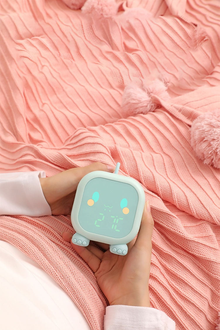 Hands Holding Kawaii Green Digital Dinosaur Alarm Clock